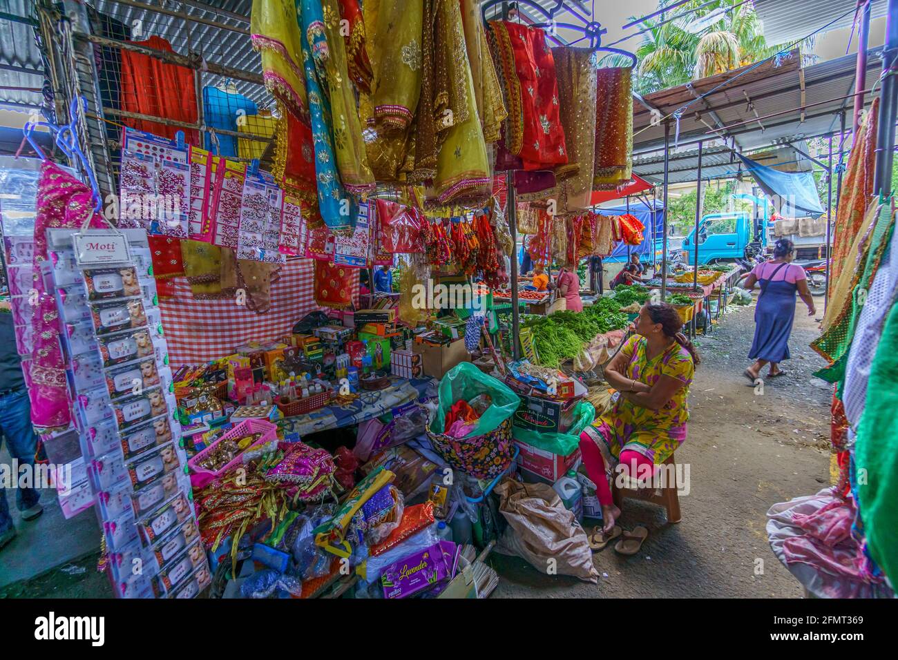 Isla de Mauricio, Océano Índico, diciembre de 2015 - Vendor femenina local, con varios productos expuestos a la venta en un mercado abierto Foto de stock