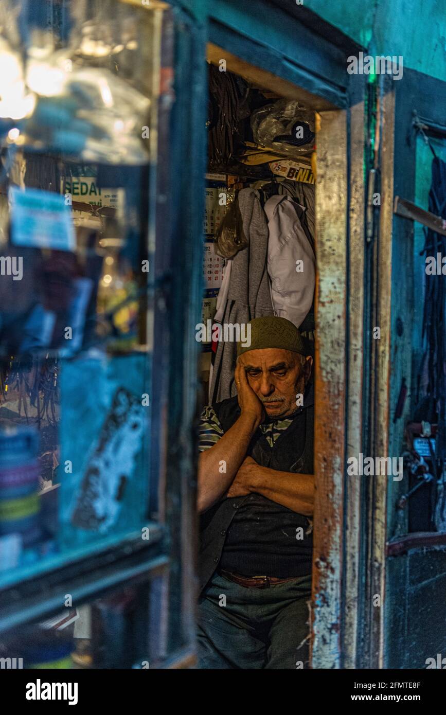 Estambul, Turquía - 10 20 2012: Zapato brillar sentado en su tienda cerca de la puerta en Estambul, Turquía. Foto de stock