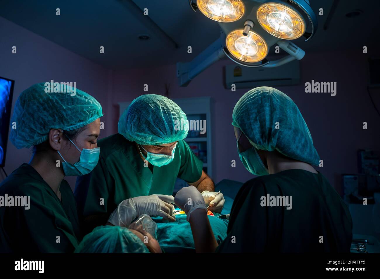 Los cirujanos con asistentes utilizaron instrumentos quirúrgicos para la cirugía Foto de stock