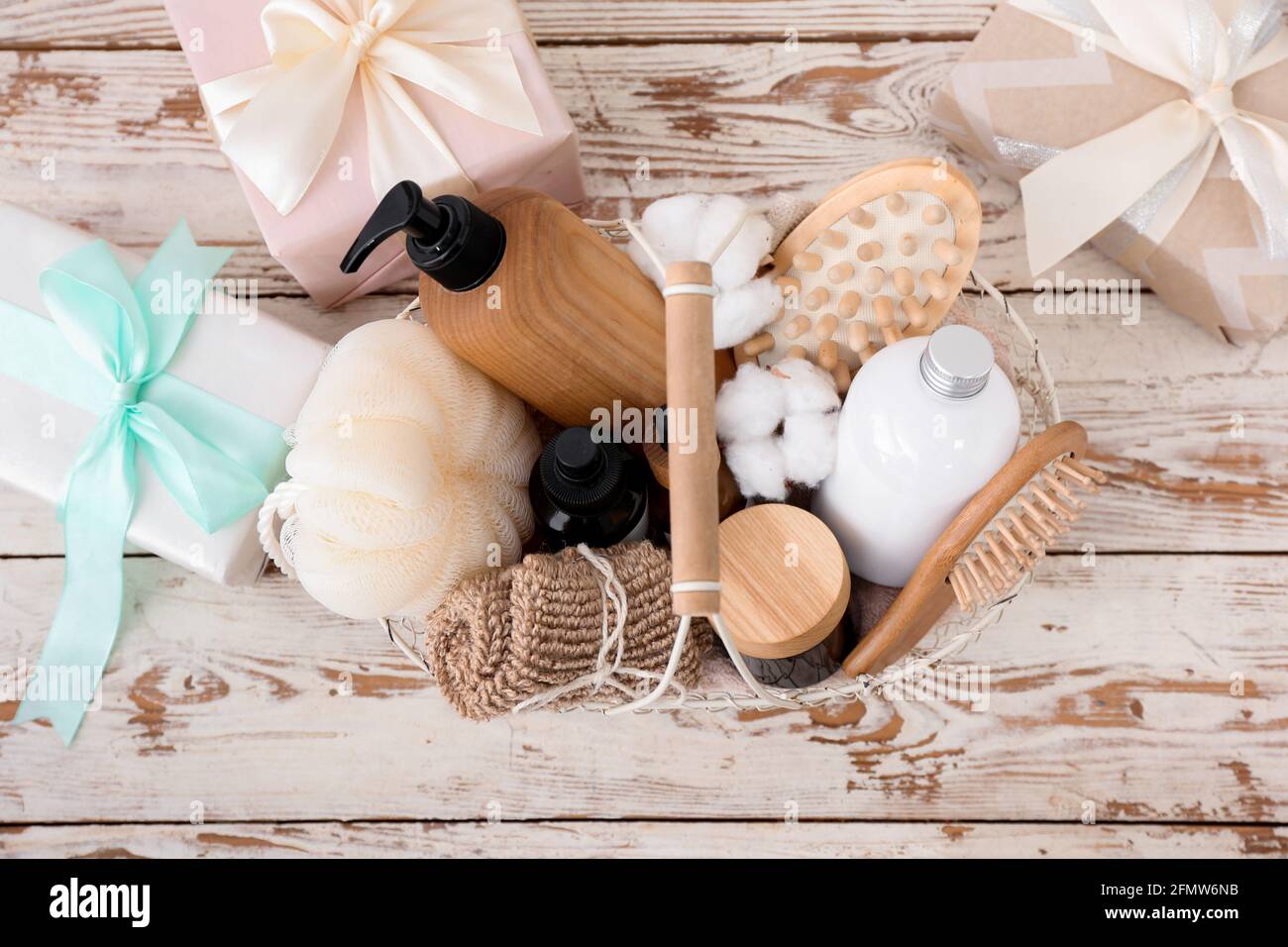 Cesta de regalo con productos cosméticos sobre fondo de madera clara  Fotografía de stock - Alamy