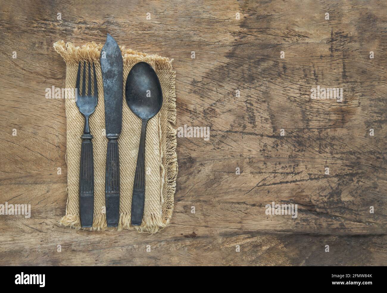 Cubiertos antiguos rústicos en un paño sobre una mesa rústica de madera.  Espacio de copia, enfoque selectivo Fotografía de stock - Alamy