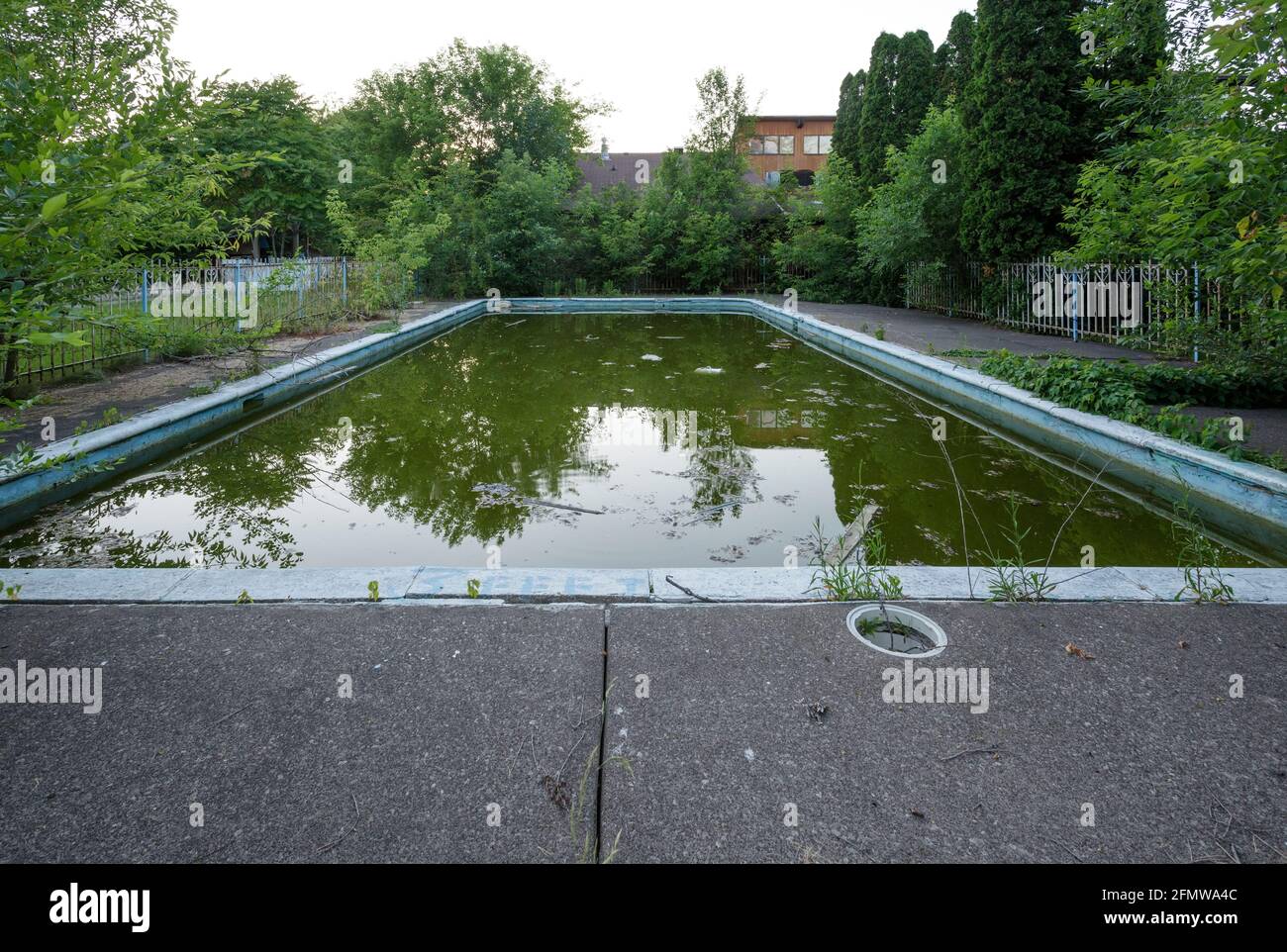Una piscina exterior muy sucia en un motel abandonado. Foto de stock