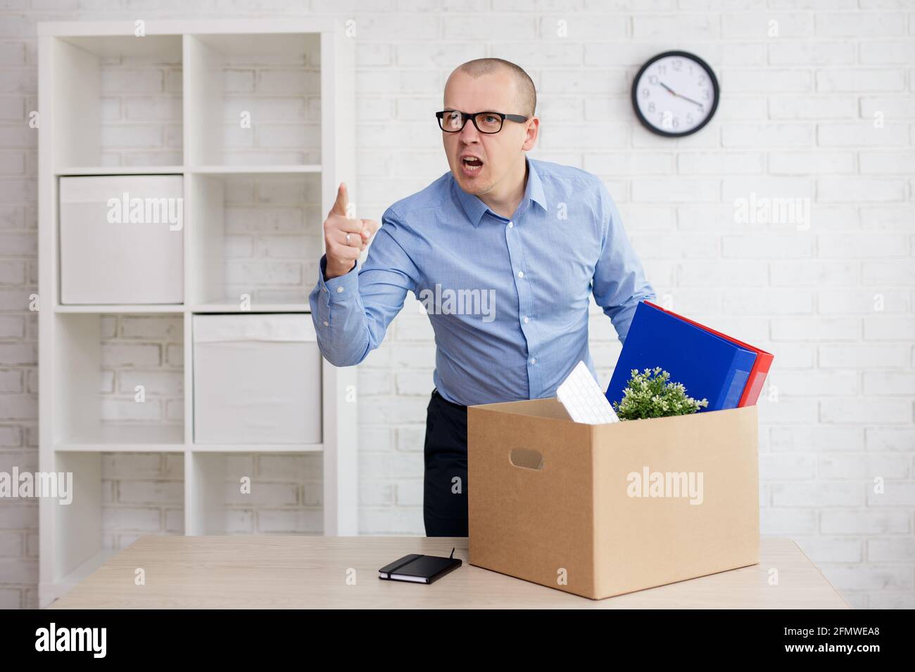 concepto de despido y conflicto laboral - enojado gritando a un empresario  despedido en la oficina con caja móvil Fotografía de stock - Alamy