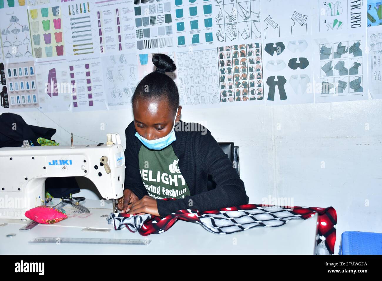 La costurera africana soga la ropa. Lugar de trabajo de sastre Fotografía  de stock - Alamy
