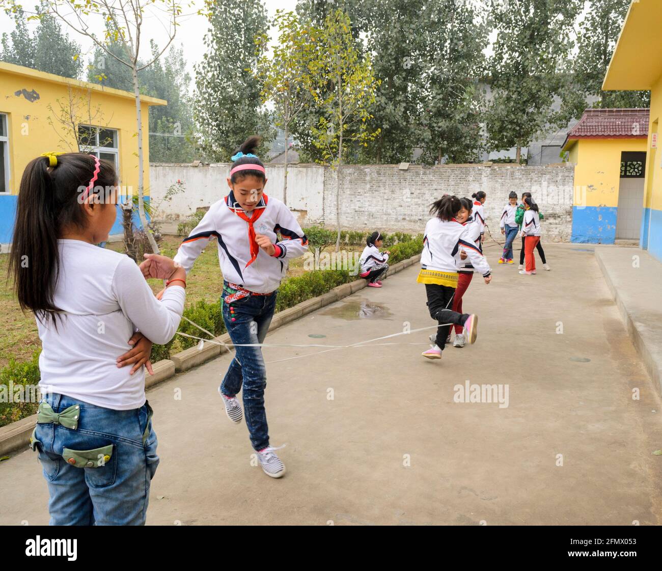 Estudiantes jugando durante el recreo en una escuela primaria rural en Qufu, Shandong, China. Foto de stock