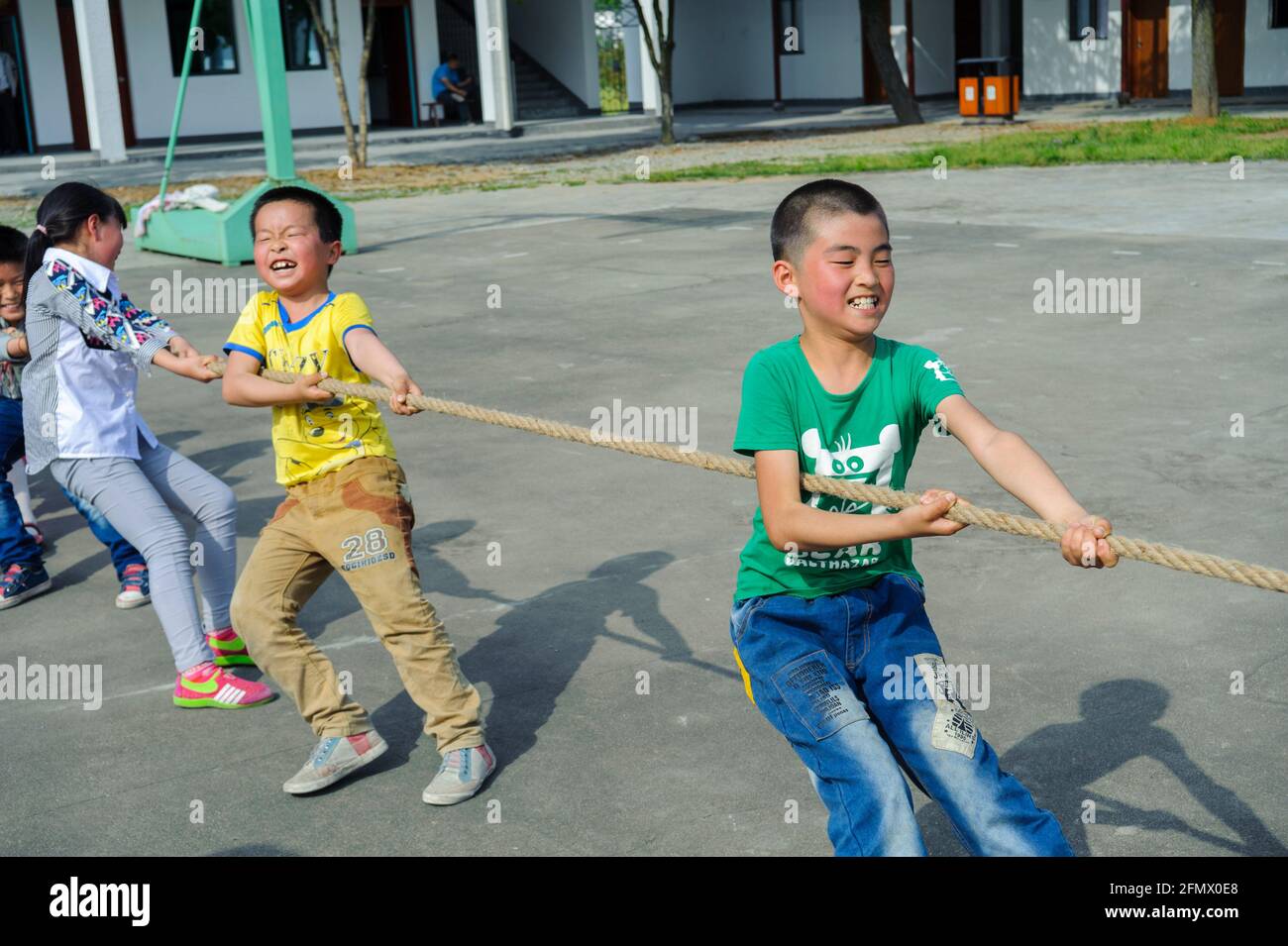 Los estudiantes de la escuela primaria central de Weiqiao en Xiuning, Anhui, China participan en una competición de tira y afloja. Foto de stock