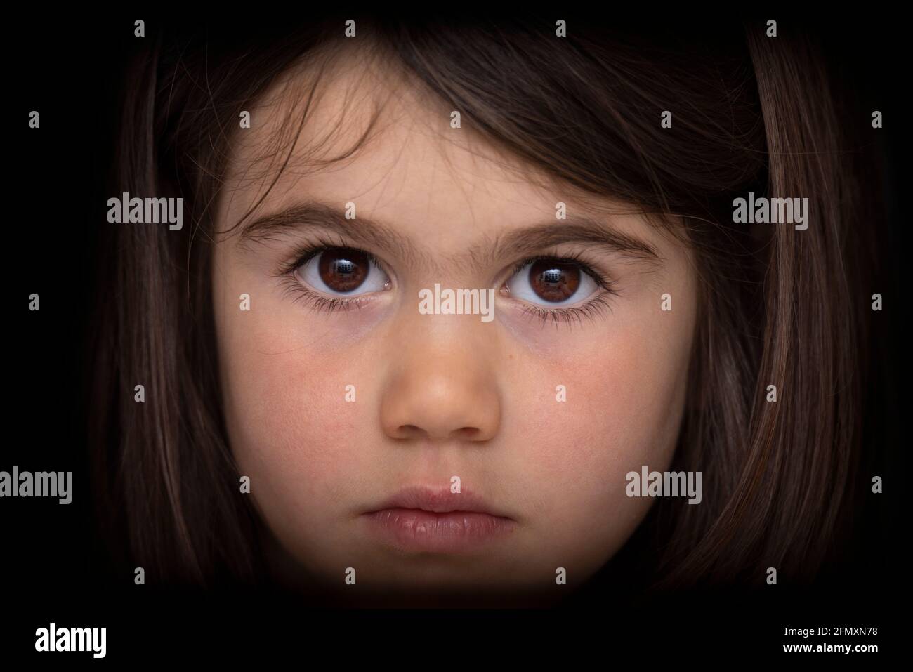 Retrato de una chica seria de cuatro años. Mirada intensa. Foto de stock