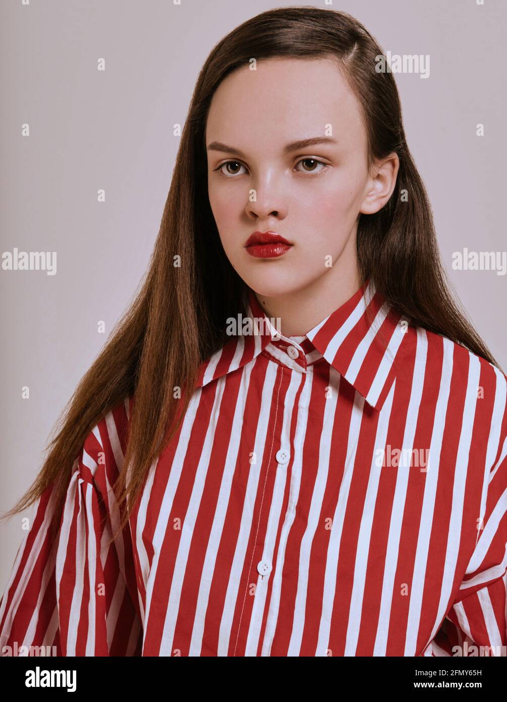 Moda chica. Mujer joven morena en el estudio en rayas rojas y blancas camisa falda blanca y sandalias de moda. Aspecto moderno Fotografía de stock - Alamy