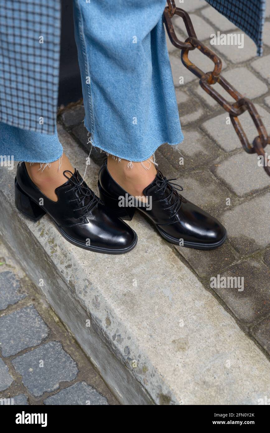 Botas de piel para mujer en primer plano. La chica camina con zapatos  negros brillantes estilo oxford Fotografía de stock - Alamy