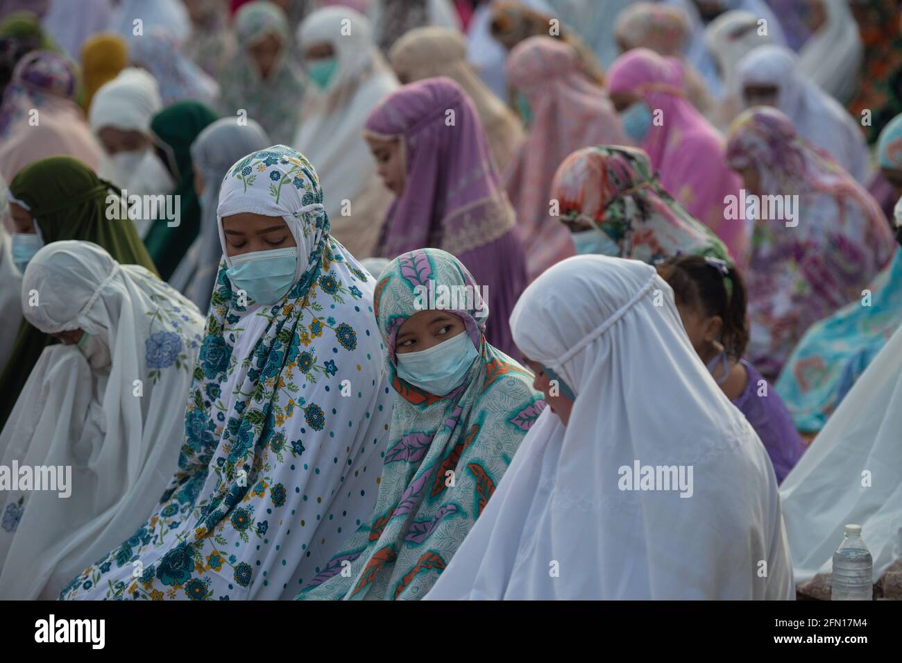 Yakarta, Indonesia. 13th de mayo de 2021. Las mujeres realizan oraciones de Eid al-Fitr en una comunidad en el norte de Yakarta, Indonesia, el 13 de mayo de 2021. Eid al-Fitr marca el final del mes de ayuno del Ramadán. Crédito: Veri Sanovri/Xinhua/Alamy Live News Foto de stock