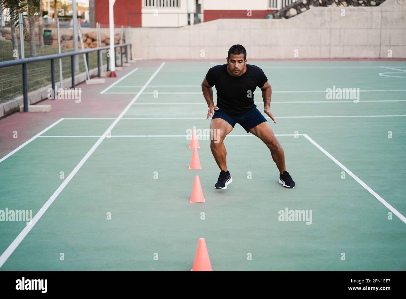 Hombre hispano haciendo ejercicios de entrenamiento con cono de velocidad y  agilidad Exteriores - Enfoque en la cara del hombre Fotografía de stock -  Alamy