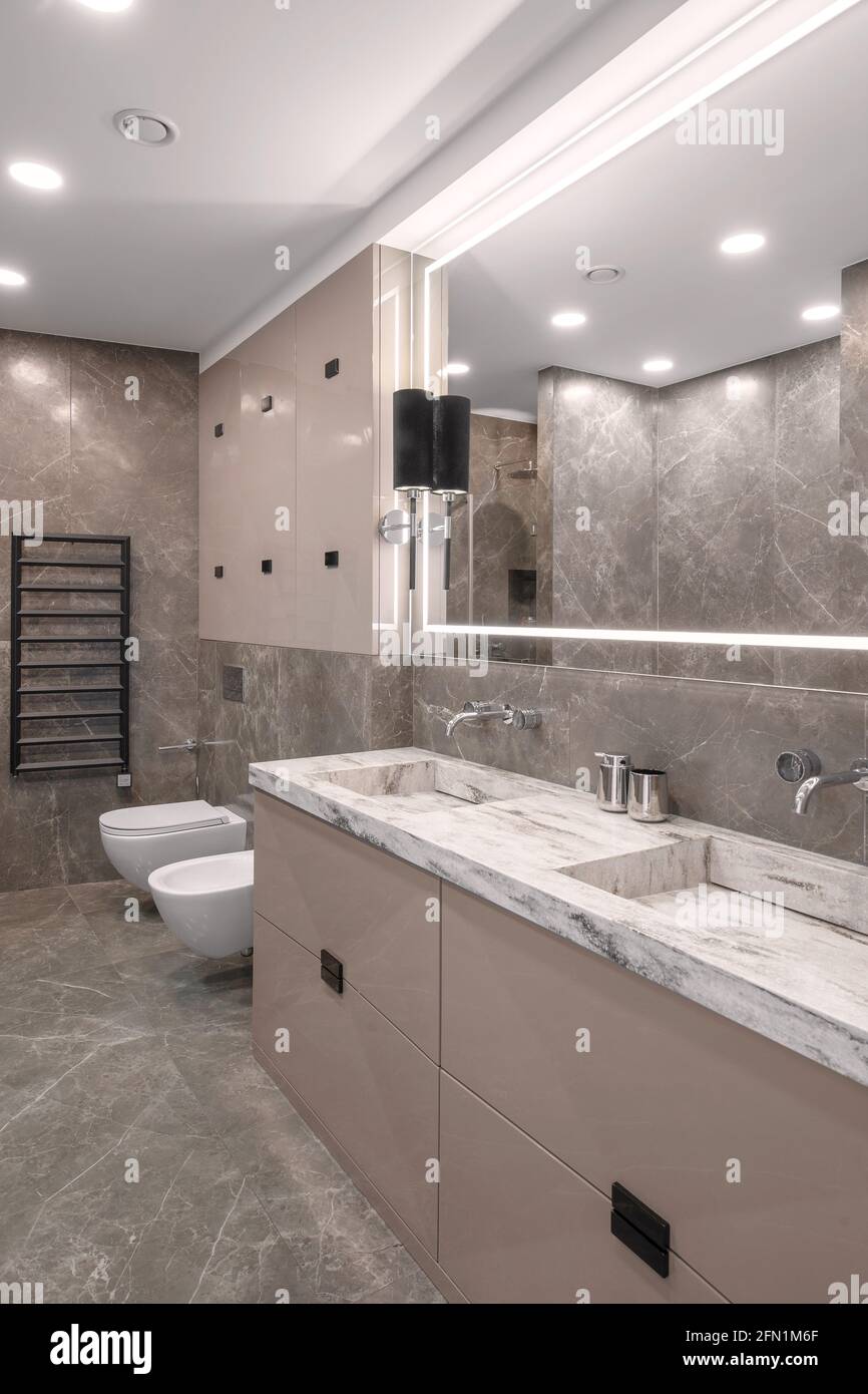 Moderno y minimalista baño de diseño interior beige con azulejos de mármol  y. muebles de color beige brillante Fotografía de stock - Alamy