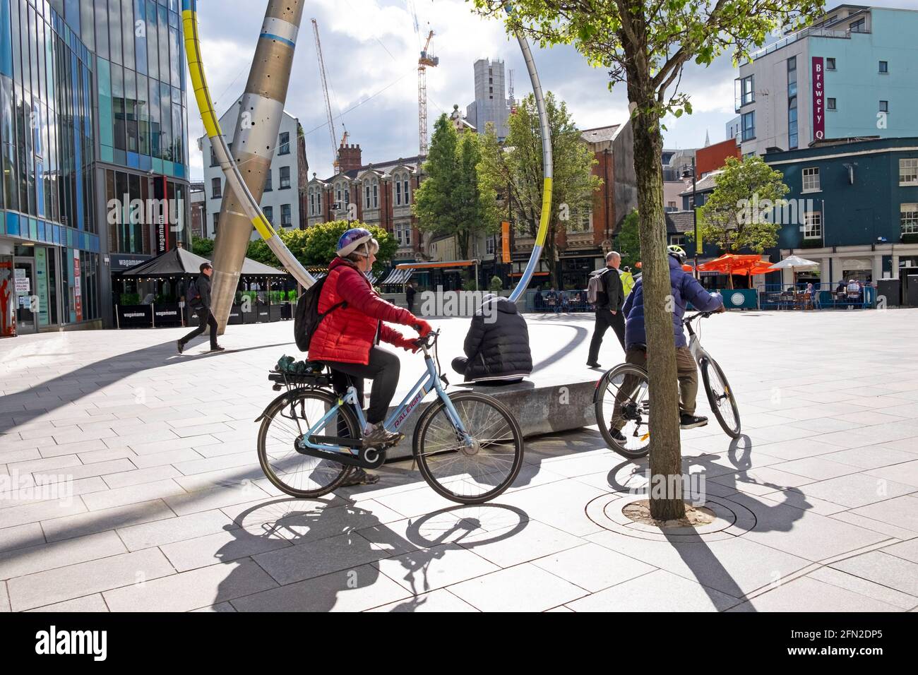 Cardiff City Center - Pareja mayor de bicicletas fuera de Central Library Escultura después de covid restricciones de cierre se aliviaron en mayo de 2021 en el Reino Unido KATHY DEWITT Foto de stock