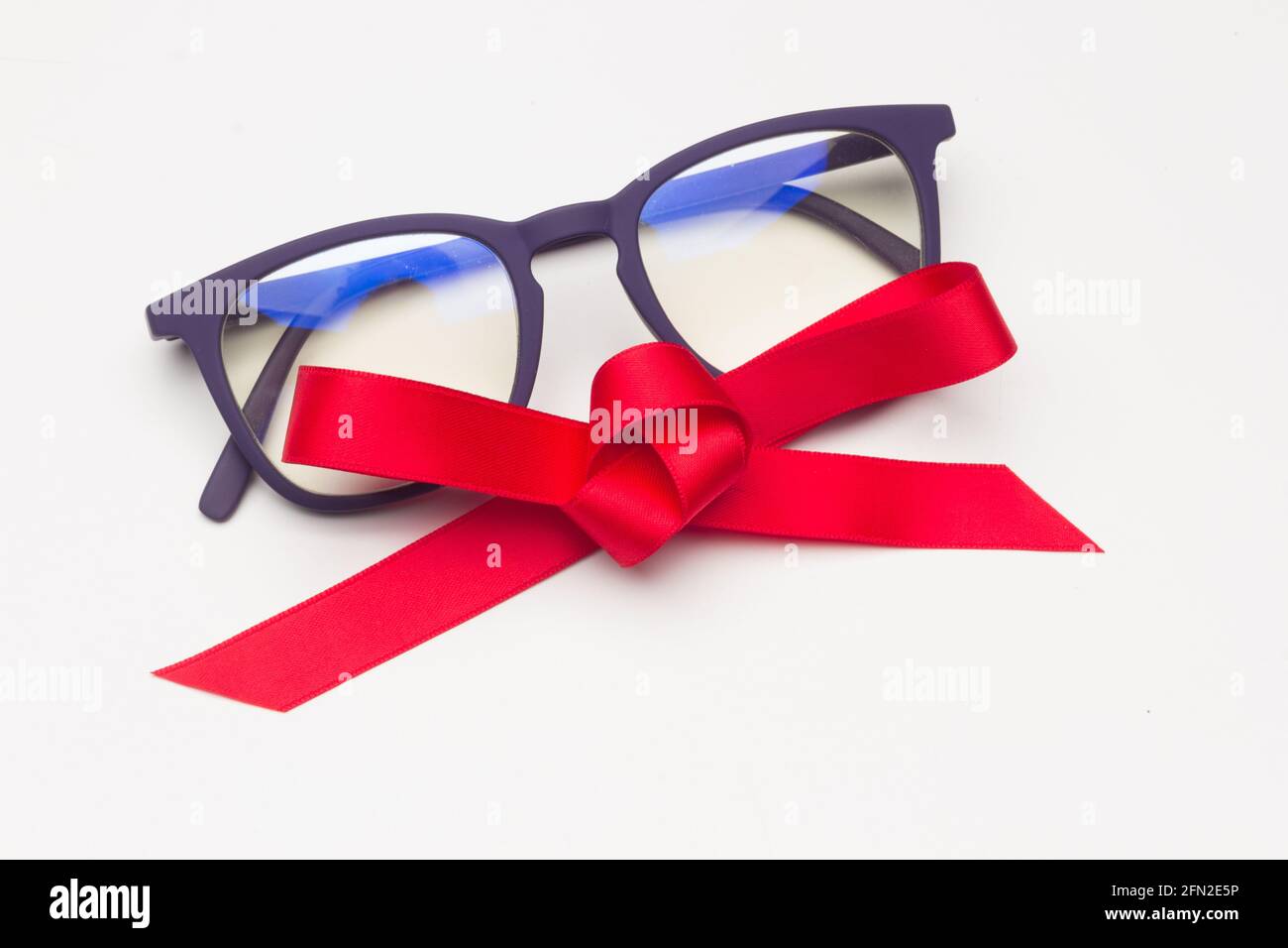Gafas con un lazo rojo sobre un fondo blanco; lentes modernas para ver mejor  puede ser un buen regalo Fotografía de stock - Alamy