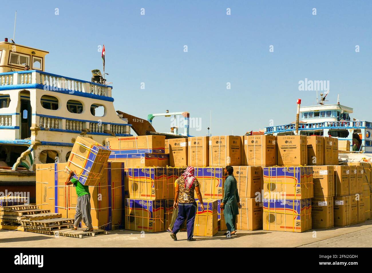 Dubai, Emiratos Árabes Unidos, 15 de abril de 2019. Trabajadores portuarios que cargan unidades de aire acondicionado en un barco en el puerto de Dubai. Foto de stock