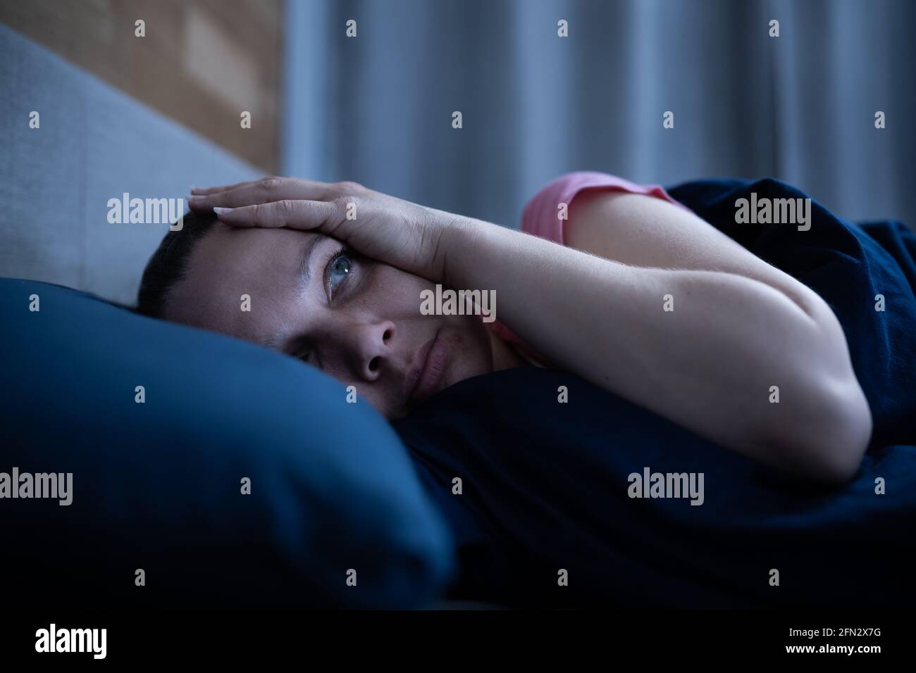 Mujer despierta con insomnio en la cama. Sueño perturbado Foto de stock