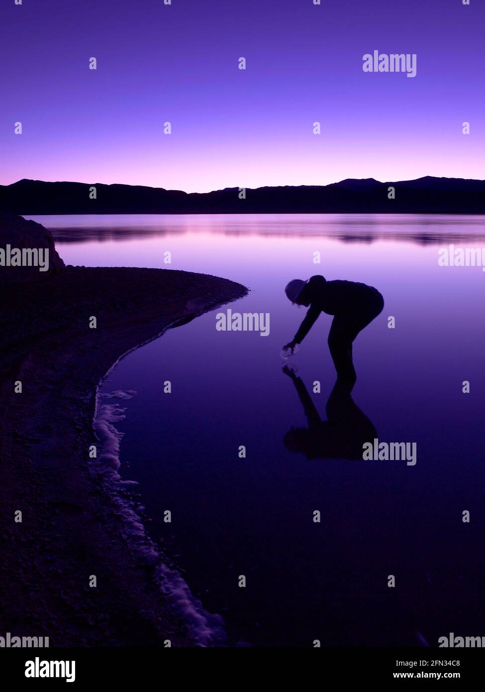 Trabajador probando agua en estanque de evaporación de litio, Silver Peak Nevada, EE.UU Foto de stock