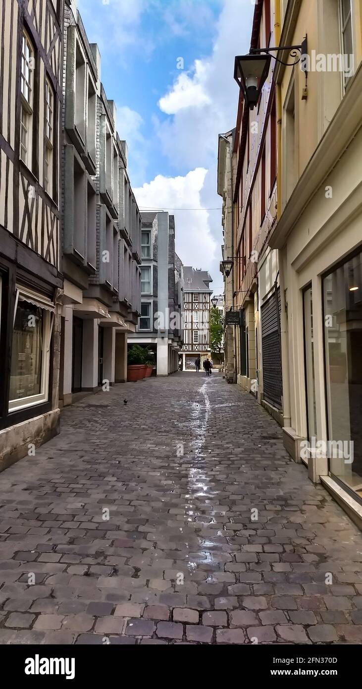 Una calle de adoquines con tiendas en cada lado en Rouen Francia. Foto de stock