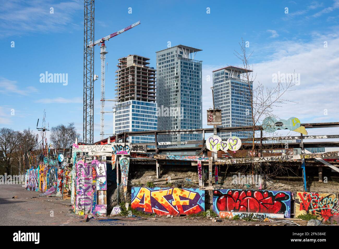 Edificios altos de Kalasatama detrás de graffiti cubrieron Suvilahti DIY Skatepark en Helsinki, Finlandia Foto de stock