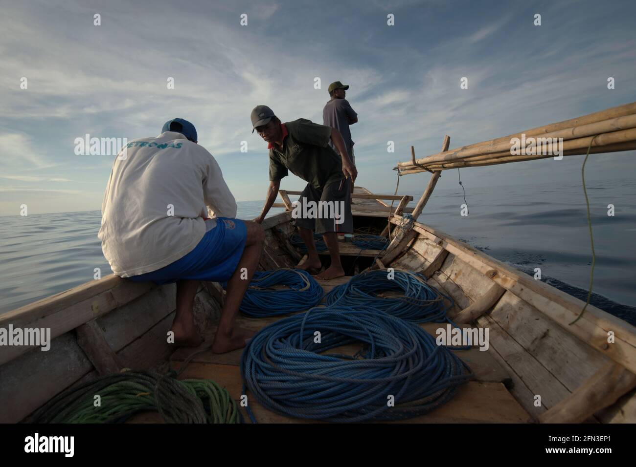 Cazadores de ballenas en el tradicional barco ballenero equipado con arpones de bambú y cuerdas, que navega por el mar de Savu frente a la costa de Lamalera en Wulandoni, Lembata, East Nusa Tenggara, Indonesia. Foto de stock