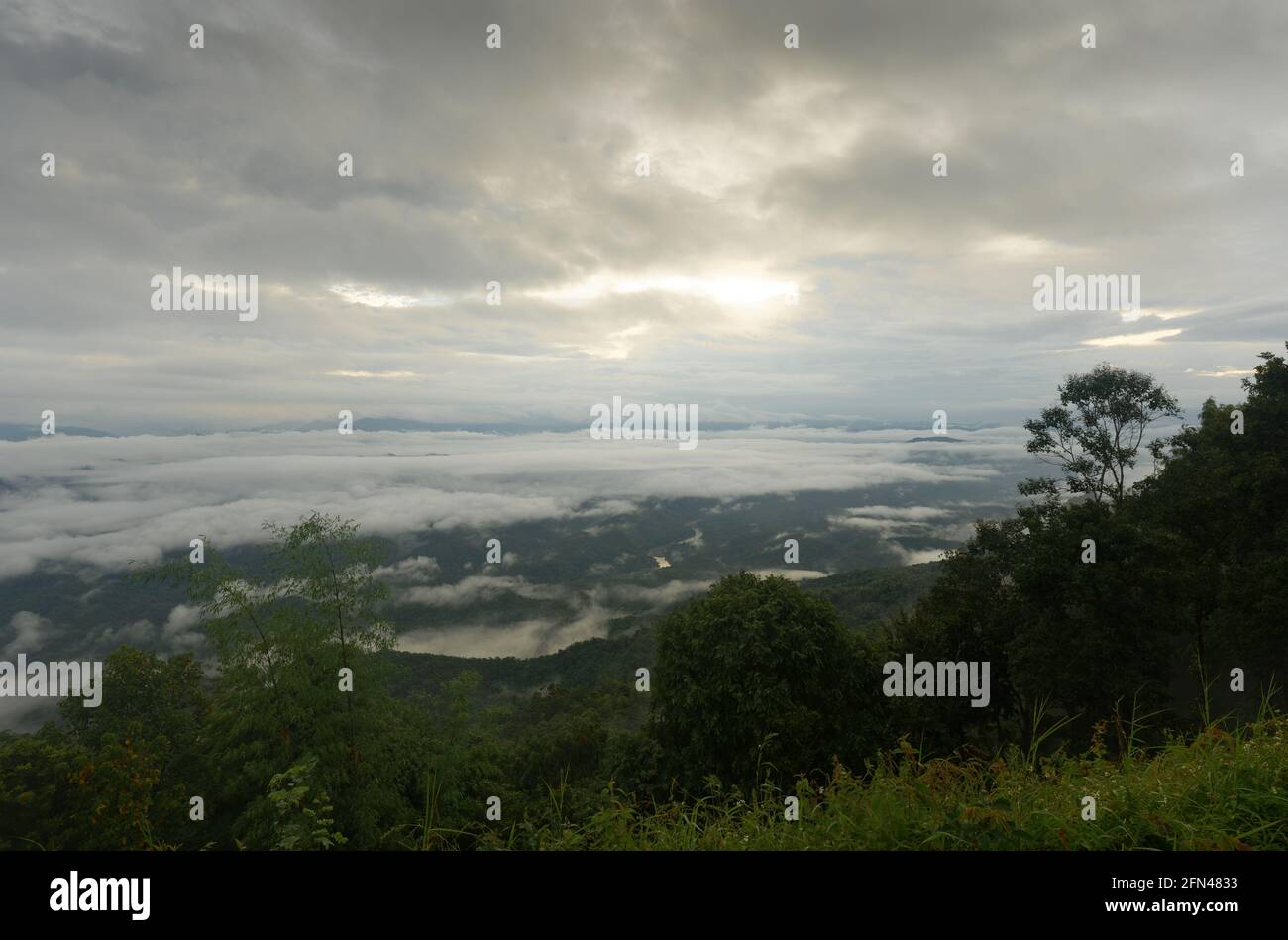 Un sombrío amanecer sobre el valle de montaña en el lado de una colina en el Parque Nacional Si Nan, Nan, Tailandia Foto de stock