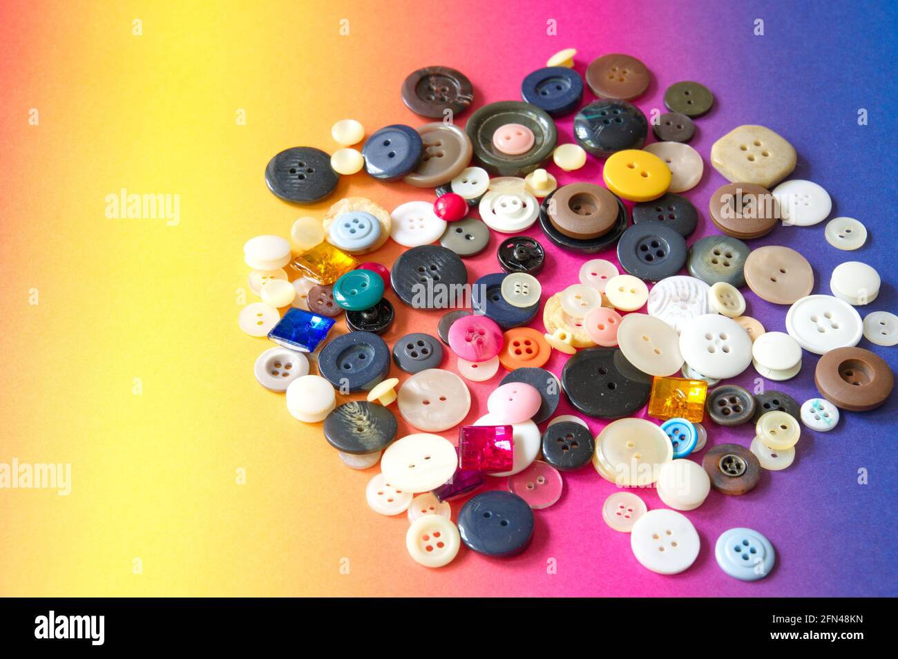 Capa plana de botones de costura sobre fondo colorido Foto de stock