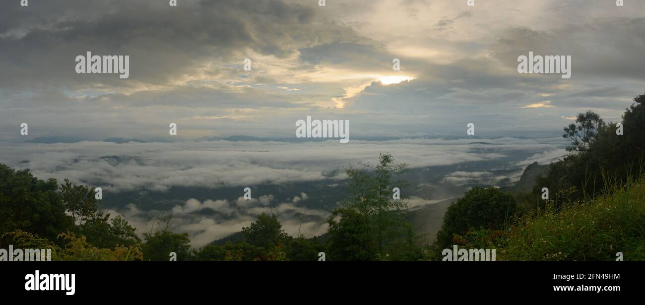 Un sombrío amanecer bañándose sobre el valle de montaña en el lado de una colina en el Parque Nacional Si Nan, Nan, Tailandia Foto de stock