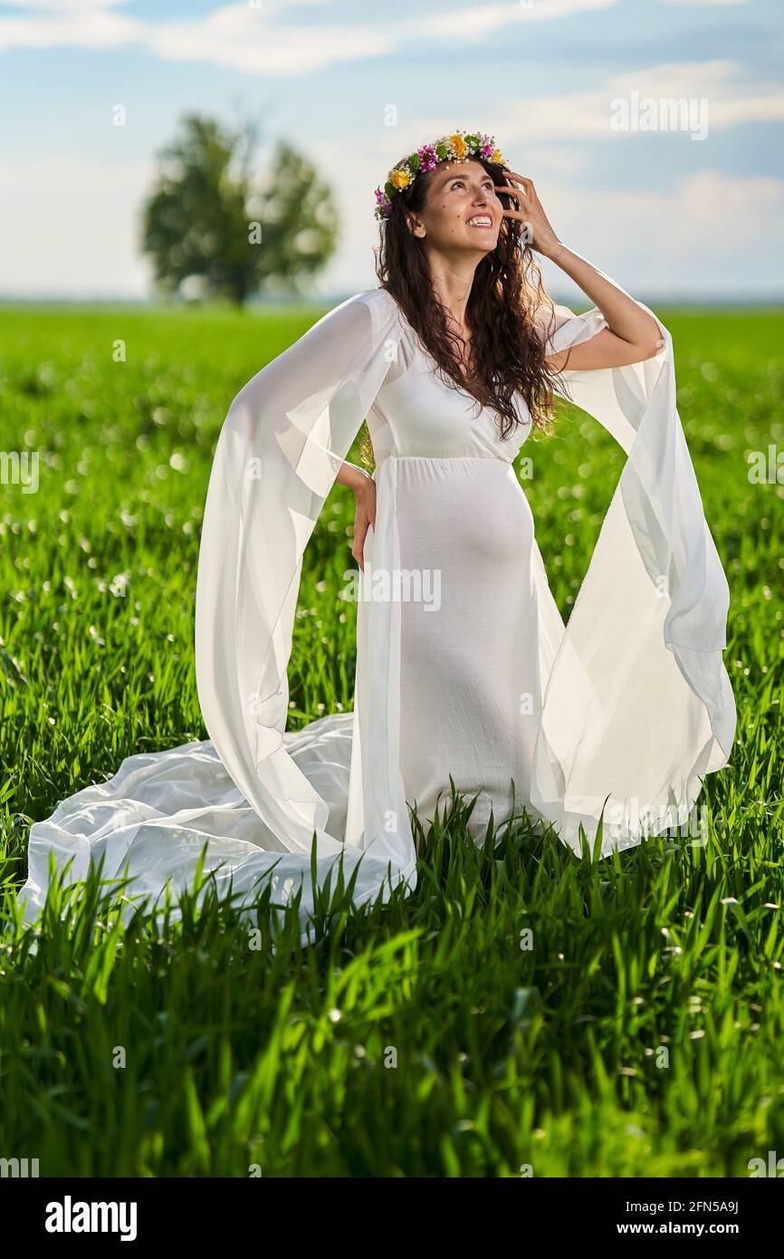 Mujer joven embarazada con un vestido blanco vaporoso en A. campo de trigo  Fotografía de stock - Alamy