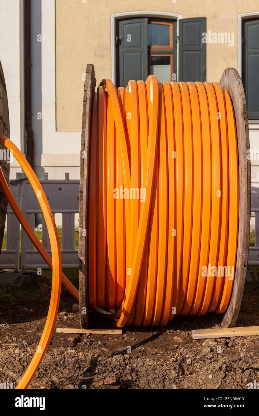 Cable telefónico naranja en un gran carrete de madera, cable de datos colocado bajo tierra Foto de stock