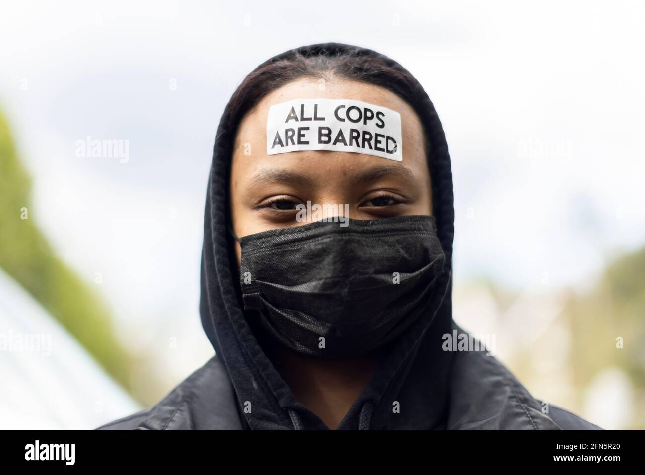 Protestador con pegatina antipolicial en la frente durante una protesta 'Kill the Bill' contra un nuevo proyecto de ley policial, Londres, 1 de mayo de 2021 Foto de stock