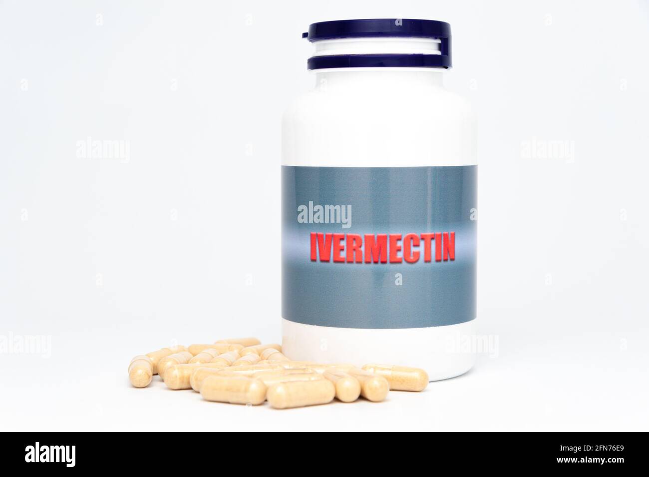 Concepto médico - botella de Ivermectin con cápsulas dispersas. Aislado sobre fondo blanco. Foto de stock