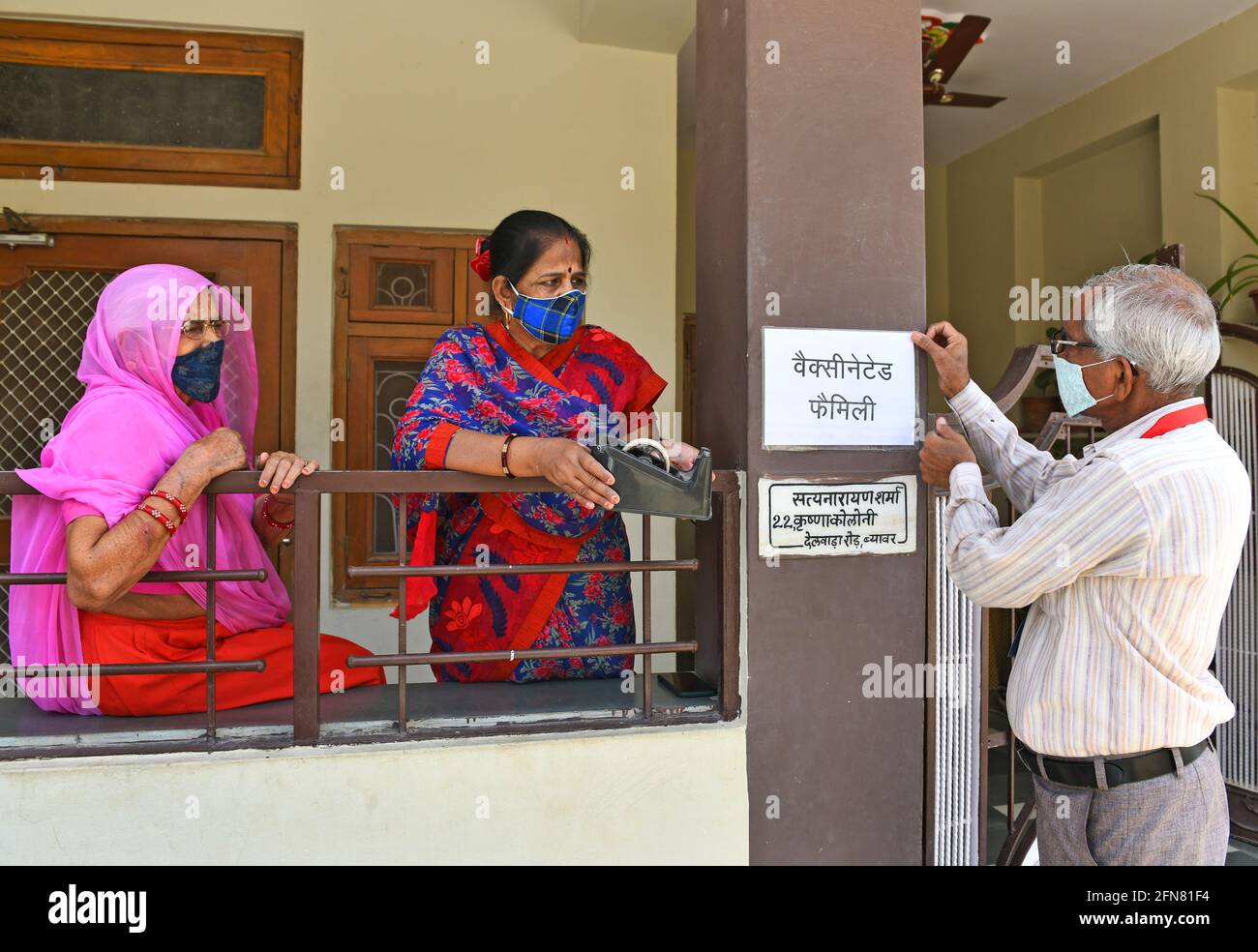 Beawar, Rajasthan, India, 15 de mayo de 2021: Satyanarayan Sharma, Un residente aplicó el cartel 'Familia Vacunada' fuera de su casa después de recibir dosis de la vacuna COVID-19 el Día Mundial de la Familia, primera iniciativa de su tipo para animar a las personas durante la segunda ola de pandemia de coronavirus en todo el país, en Beawar. El cartel presentó un objetivo de eliminar las ideas erróneas sobre la vacunación contra Covid-19 y de animar a las personas con respecto a la vacuna contra la enfermedad de coronavirus. Crédito: Sumit Saraswat/Alamy Live News Foto de stock