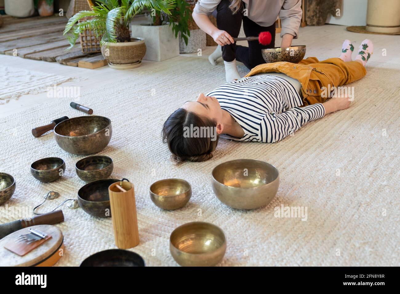 Dos mujeres hacen masaje de cuencos tibetanos en casa, practican juntos la  terapia de sonido tibet para la meditación Fotografía de stock - Alamy