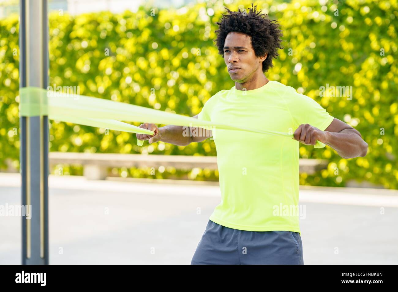 Hombre negro haciendo ejercicio con banda elástica al aire libre Foto de stock