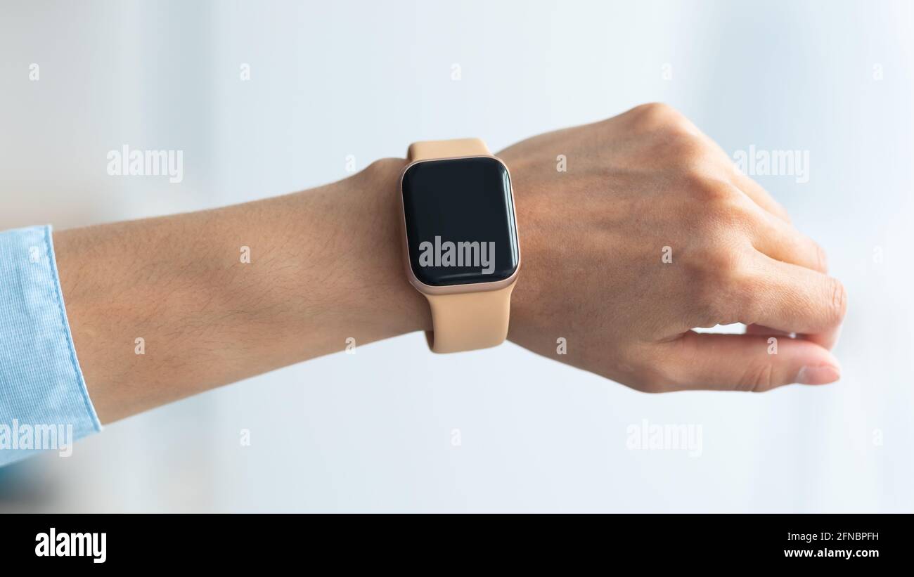 Mano femenina con reloj inteligente con pantalla negra en blanco Fotografía  de stock - Alamy