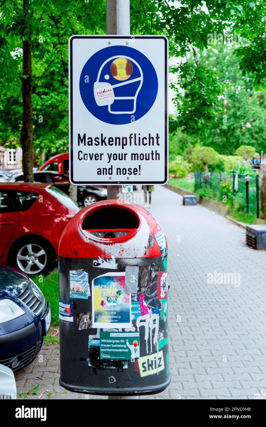 En la plaza Neumarkt de Mannheim/Alemania un cartel le dice a los peatones que cubran la boca y la nariz durante la pandemia de Covid-19. 15 de mayo de 2021 Foto de stock