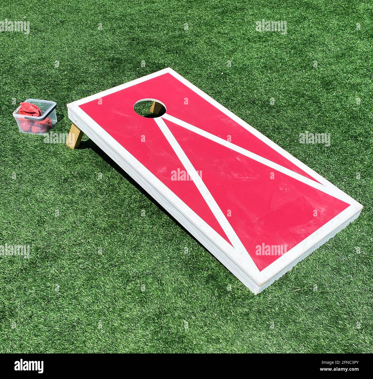 La bolsa de frijoles rojos y blancos sacude el juego de la cornhole en un  campo verde del césped Fotografía de stock - Alamy
