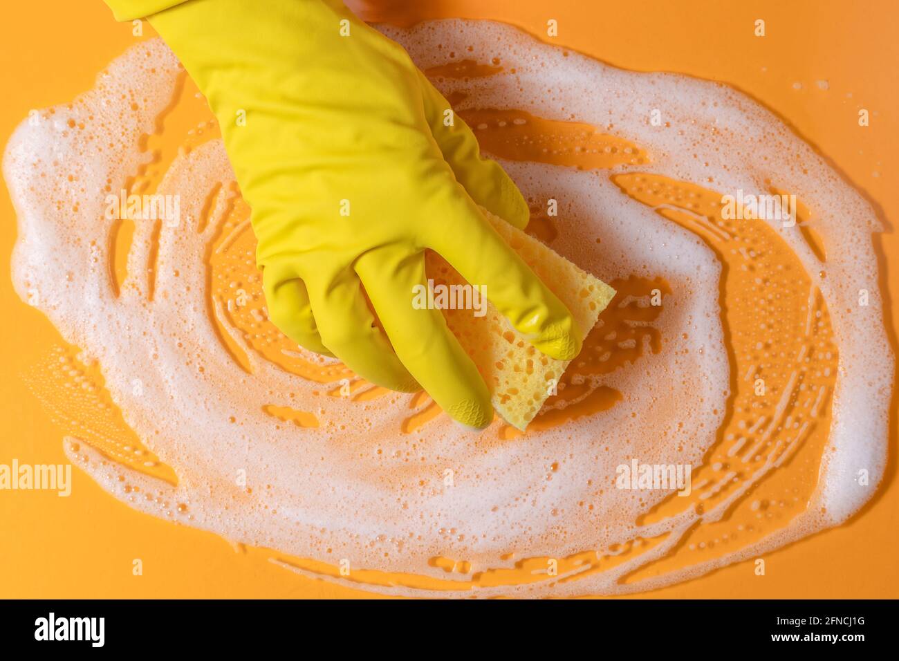 Esponja de limpieza con jabón. Textura con burbujas sobre fondo amarillo. Espacio de copia. Limpieza con esponja. Foto de stock