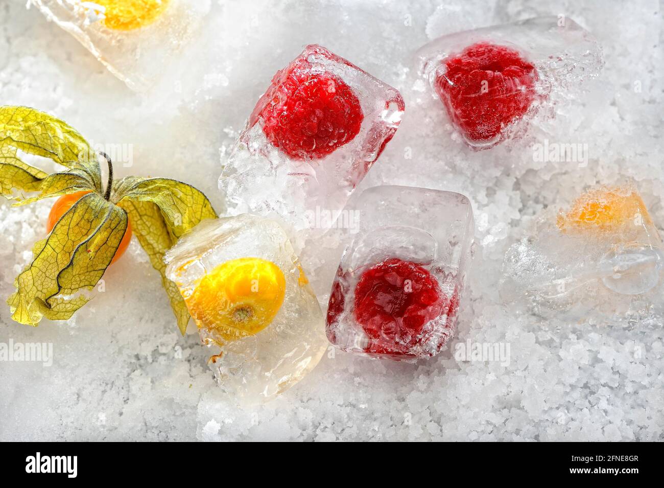 Frambuesas congeladas en cubitos de hielo Foto de stock