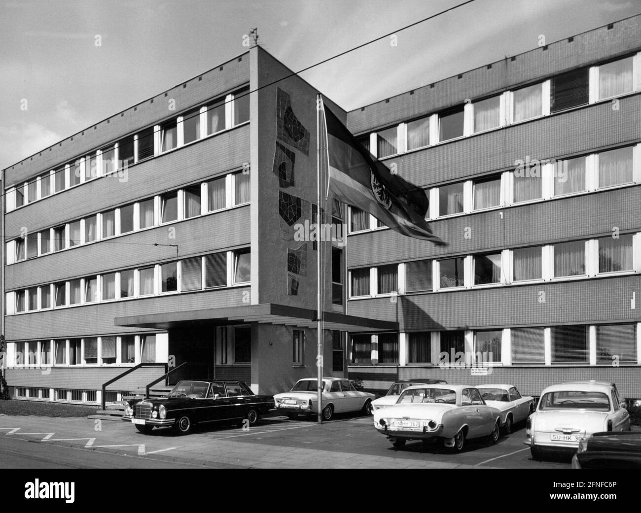 Algunos coches están estacionados frente al Ministerio Federal de Cooperación y Desarrollo Económicos de Bonn. [traducción automática] Foto de stock