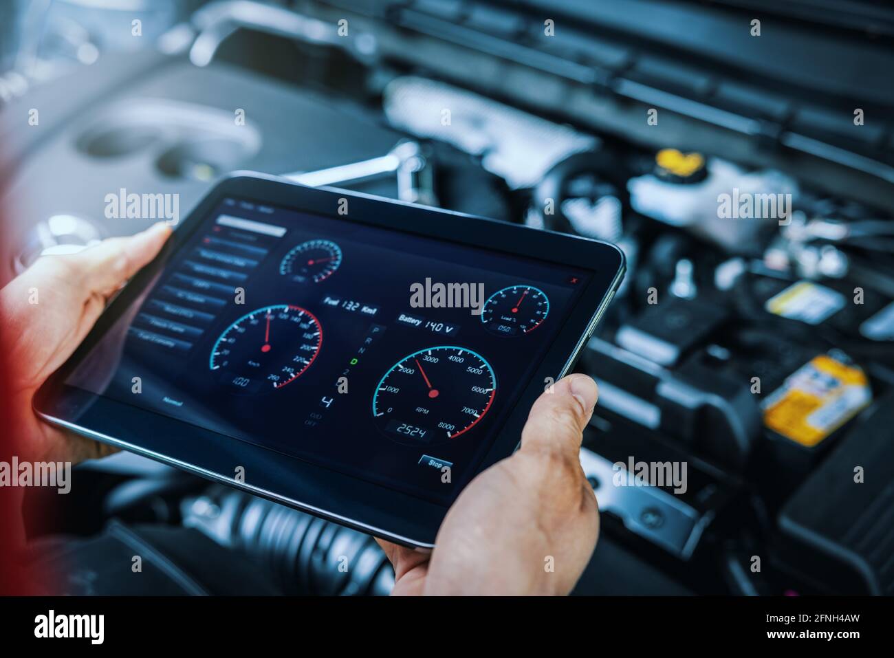 diagnóstico del motor del automóvil. mecánico de servicio usando una tableta digital para inspeccionar el estado del vehículo Foto de stock