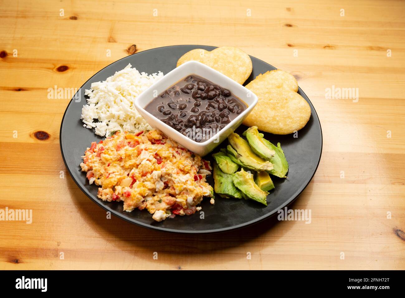 El desayuno típico venezolano revuelto huevos con tomate llamado Perico,  frijoles negros, queso blanco duro, arepas y aguacate Fotografía de stock -  Alamy