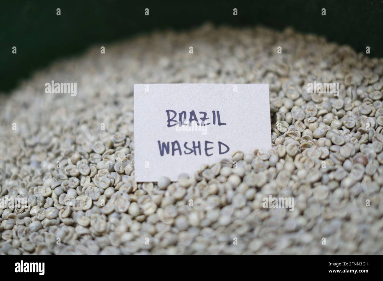los granos de café verdes de proceso lavados orgánicos esperan a ser tostados en la casa de café por lista. Foto de stock