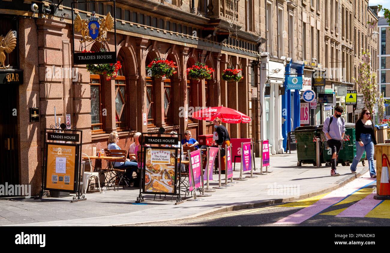 Dundee, Tayside, Escocia, Reino Unido. 18th de mayo de 2021. Clima en el Reino Unido: Cálido sol primaveral en el noreste de Escocia con temperaturas que alcanzan los 15°C. Las restricciones de cierre de Covid-19 ahora se relajan hasta el nivel 2 en Dundee, viendo a la gente aprovechar las nuevas regulaciones relajadas y socializar dentro y fuera de los pubs locales. Las restricciones de nivel 2 permiten que los pubs de Dundee permanezcan abiertos hasta las 10,30pm horas para los negocios con clientes de fuera disfrutando del tiempo bebiendo y cenando en el bar de Trades House en el centro de la ciudad. Crédito: Dundee Photographics/Alamy Live News Foto de stock