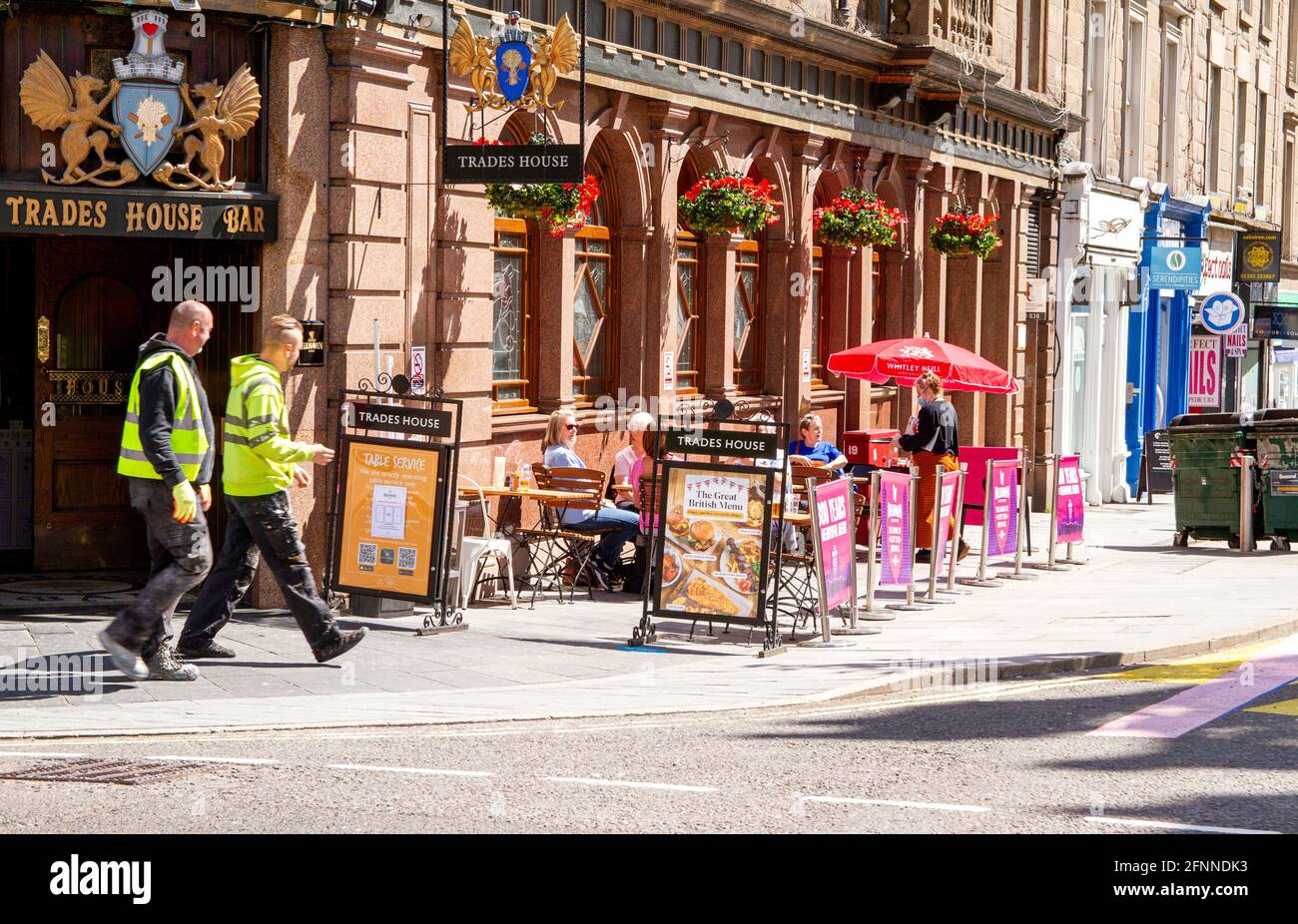 Dundee, Tayside, Escocia, Reino Unido. 18th de mayo de 2021. Clima en el Reino Unido: Cálido sol primaveral en el noreste de Escocia con temperaturas que alcanzan los 15°C. Las restricciones de cierre de Covid-19 ahora se relajan hasta el nivel 2 en Dundee, viendo a la gente aprovechar las nuevas regulaciones relajadas y socializar dentro y fuera de los pubs locales. Las restricciones de nivel 2 permiten que los pubs de Dundee permanezcan abiertos hasta las 10,30pm horas para los negocios con clientes de fuera disfrutando del tiempo bebiendo y cenando en el bar de Trades House en el centro de la ciudad. Crédito: Dundee Photographics/Alamy Live News Foto de stock