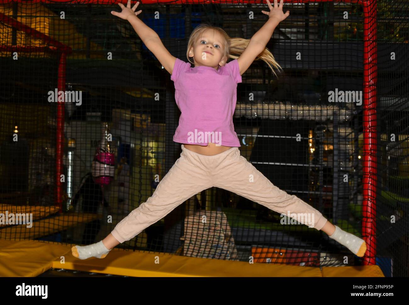 Niña saltando en un trampolín en el centro de juegos Fotografía de stock -  Alamy