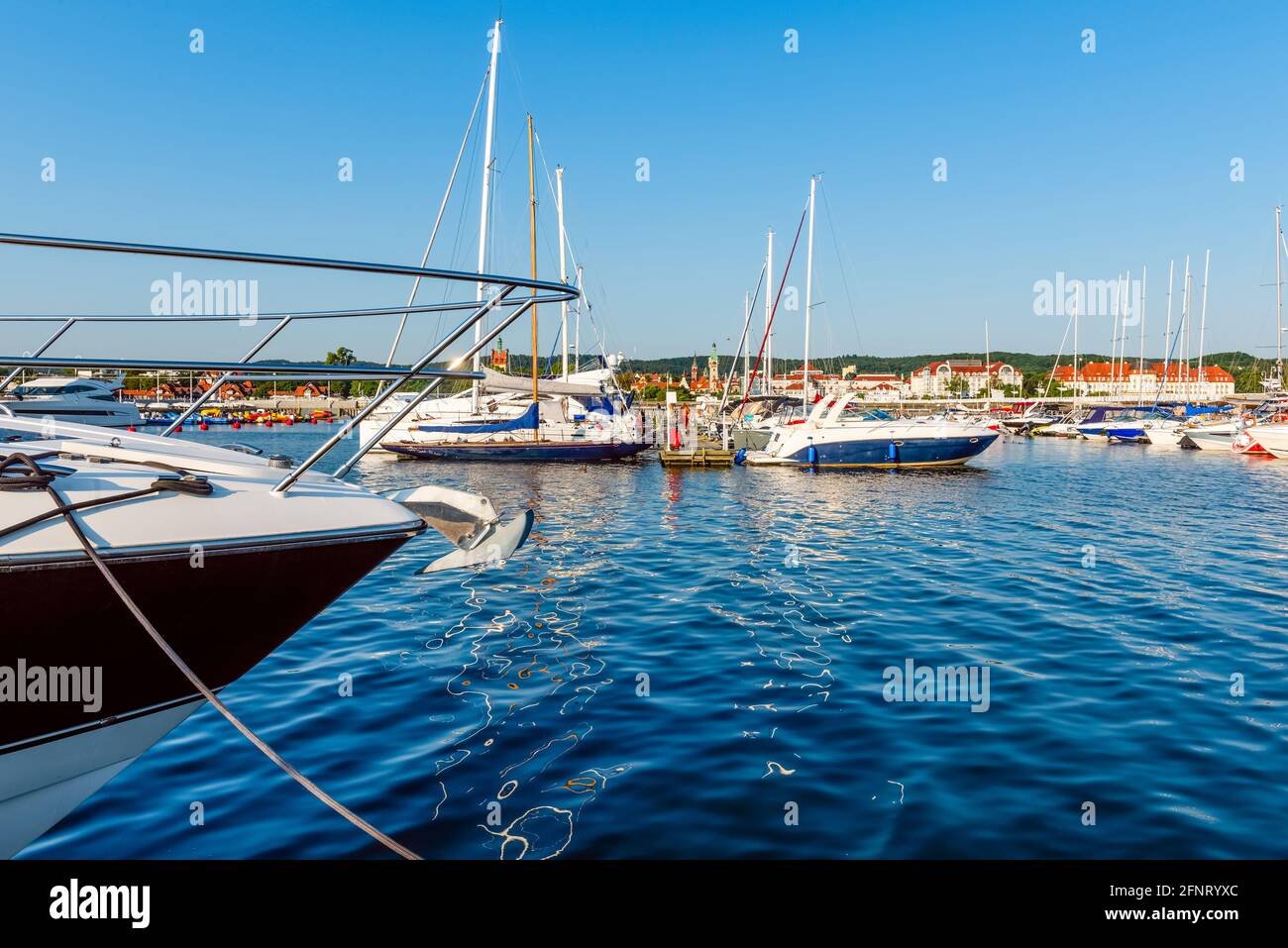 Yates de vela amarrados en un muelle en un puerto del mar báltico en una mañana soleada. Embarcación náutica para chárter Foto de stock