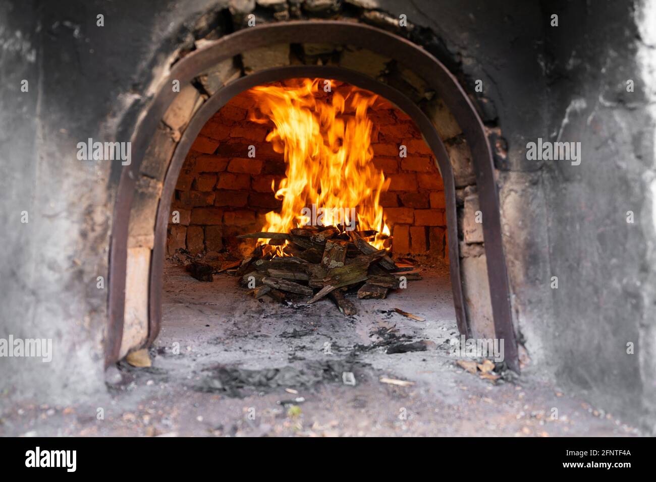 Fuego dentro de un horno de ladrillo que se quema para calentar el horno  para la preparación de un cordero Fotografía de stock - Alamy