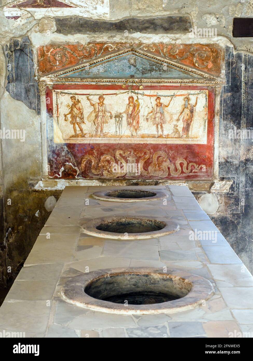 La zona del bar sirve comida y bebida. El mostrador de mármol tiene tarros en la encimera que se utilizaban para guardar la comida. Casa e Thermopolium di Vetutius Placidus (Termopolio y casa de Vetutius Placidus) - Sitio arqueológico de Pompeya, Italia Foto de stock