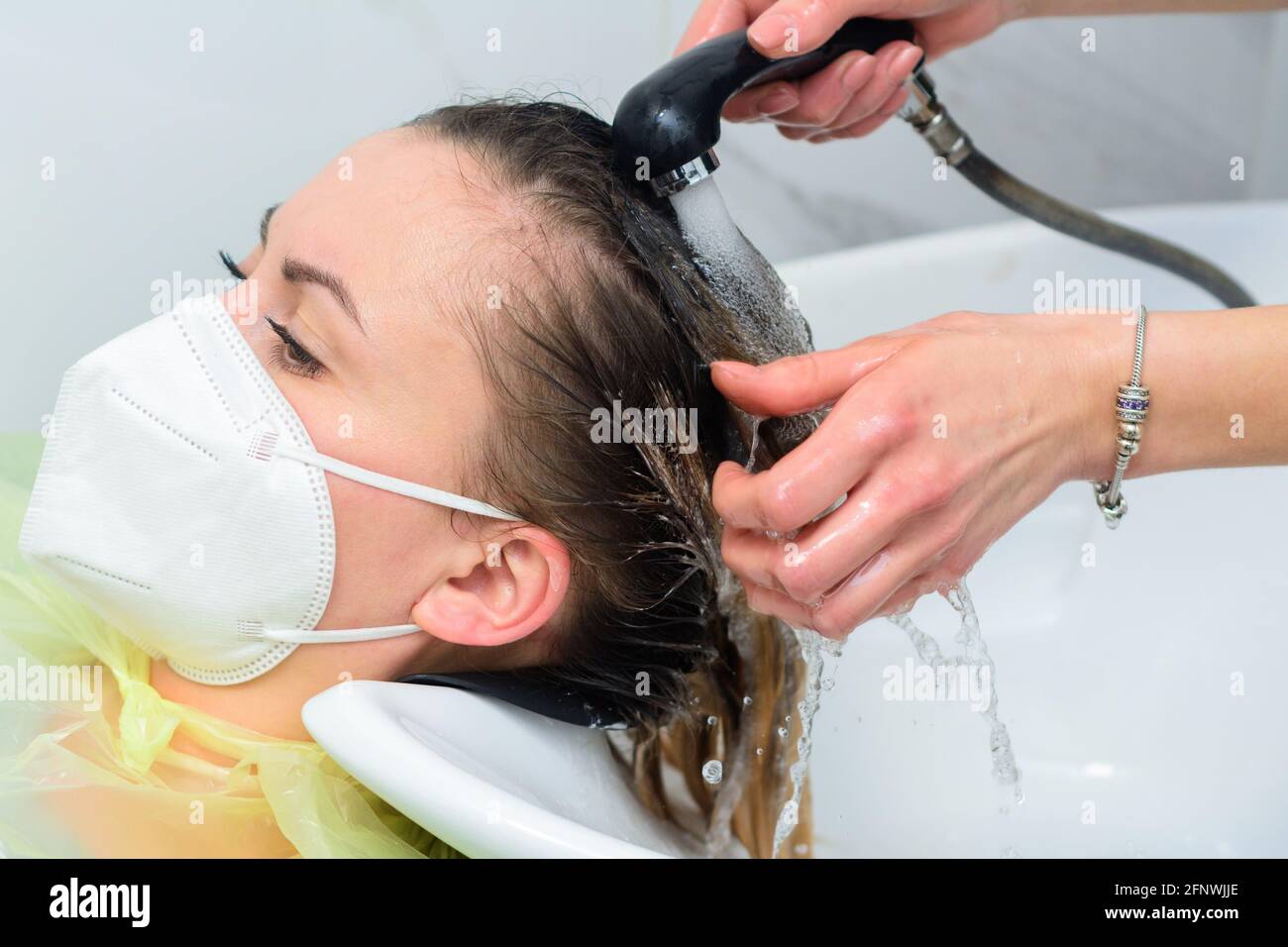 El peluquero lava el tinte del pelo, el lavado del cuero cabelludo y el